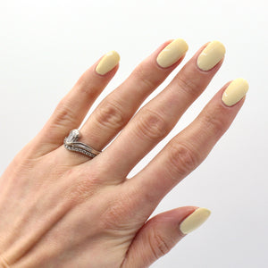 Pastel yellow nail polish swatch on pale skin tone