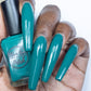 Emerald green nail polish swatch on medium dark skin tone
