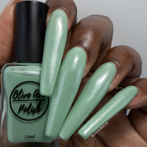 sage green shimmery nail polish swatch on deep skin tone