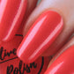coral shimmer nail polish swatch on pale skin tone