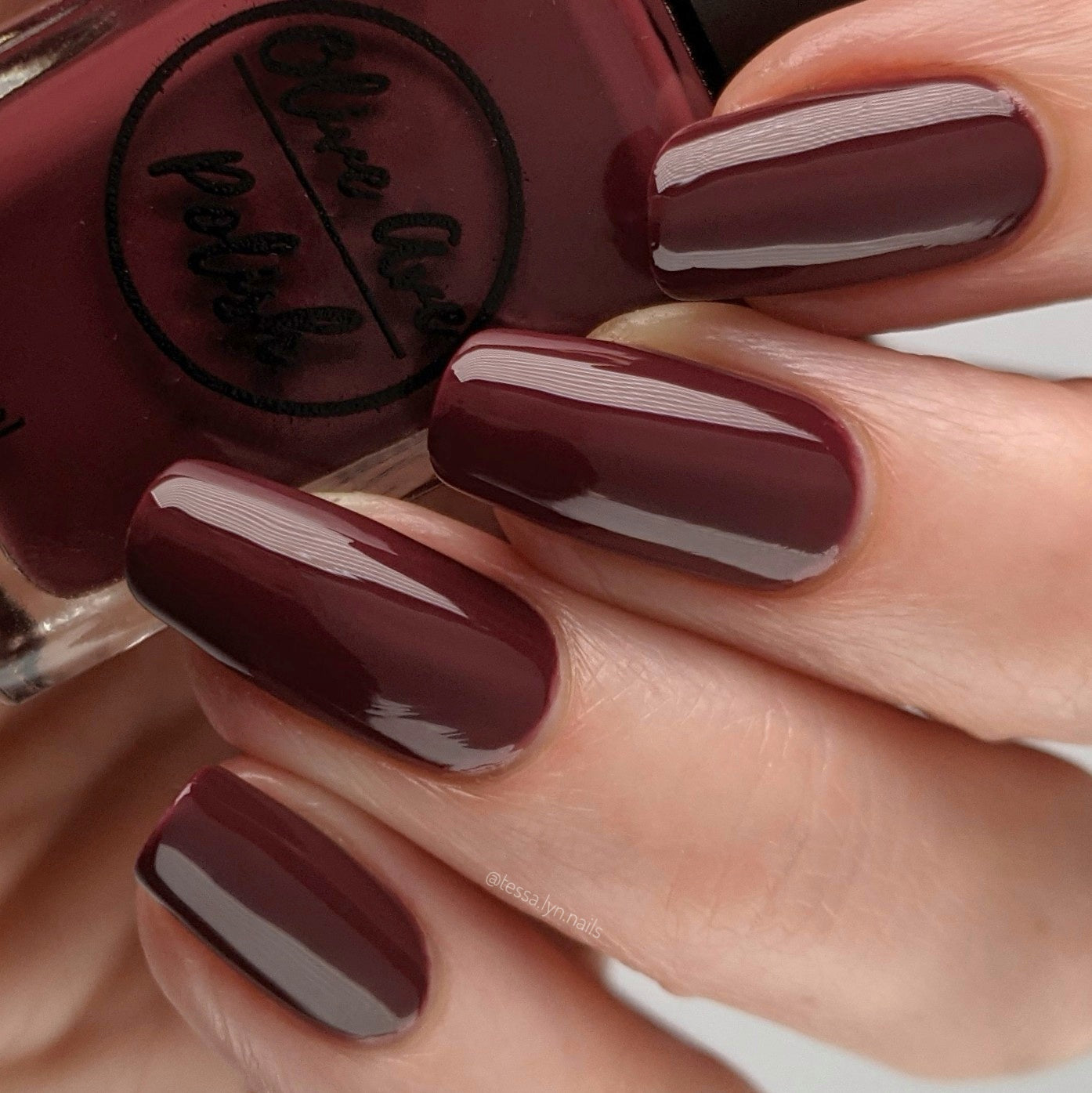 Burgundy wine nail polish swatch on pale skin tone