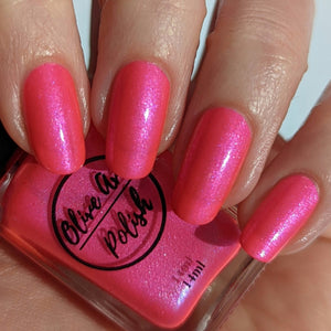 Pink glitter nail polish swatch on pale skin tone
