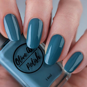 Dusty cerulean blue nail polish swatch on pale skin tone