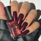 burgundy nail polish with gold shimmer swatch on pale skin tone