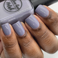 purple grey nail polish swatch on medium dark skin tone