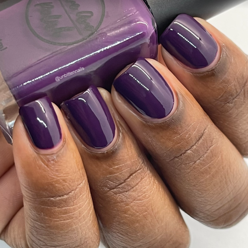 deep purple nail polish swatch on medium deep skin tone