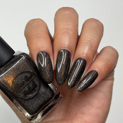 brown holographic nail polish swatch on pale skin tone