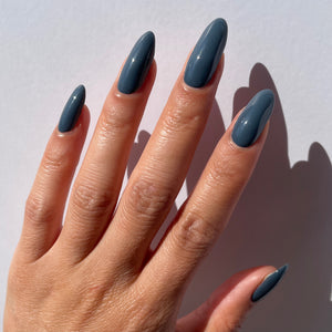 blue grey nail polish swatch on pale skin tone
