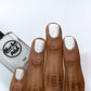 Off white nail polish swatch on medium dark skin tone