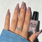 Shimmery taupe nail polish swatch on pale skin tone