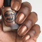 Bronze nail polish swatch on medium dark skin tone