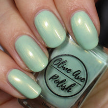 Load image into Gallery viewer, Spring green nail polish on pale skin tone