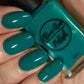 Emerald green nail polish swatch on pale skin tone