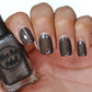 brown holographic nail polish swatch on pale skin tone