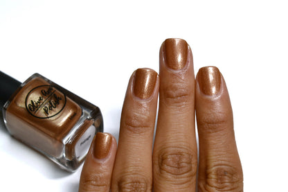Bronze nail polish swatch on medium skin tone