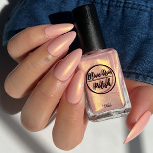 Pink nail polish with gold shimmer swatch on pale skin tone