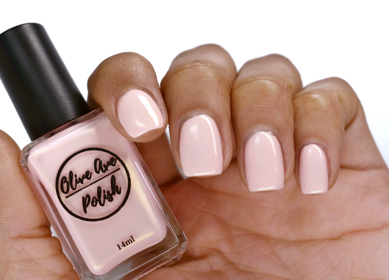 Pink nail polish with gold shimmer swatch on pale skin tone
