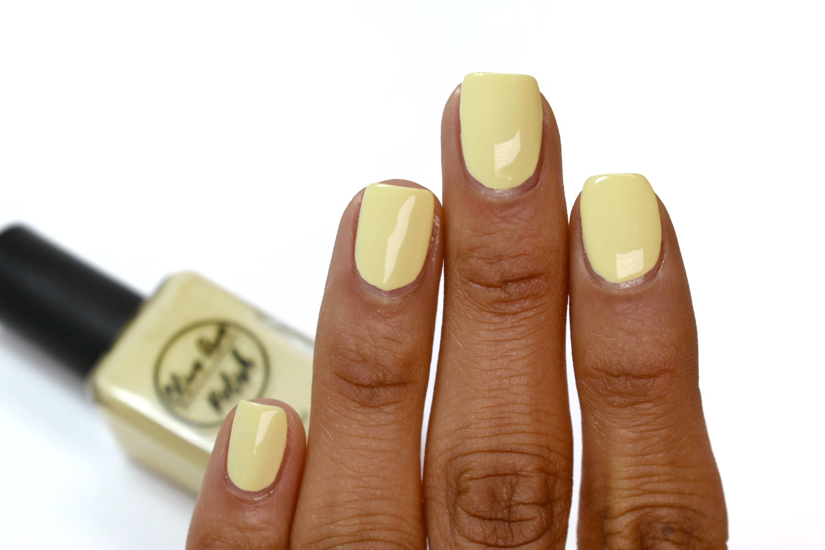 pastel yellow nail polish swatch on medium skin tone