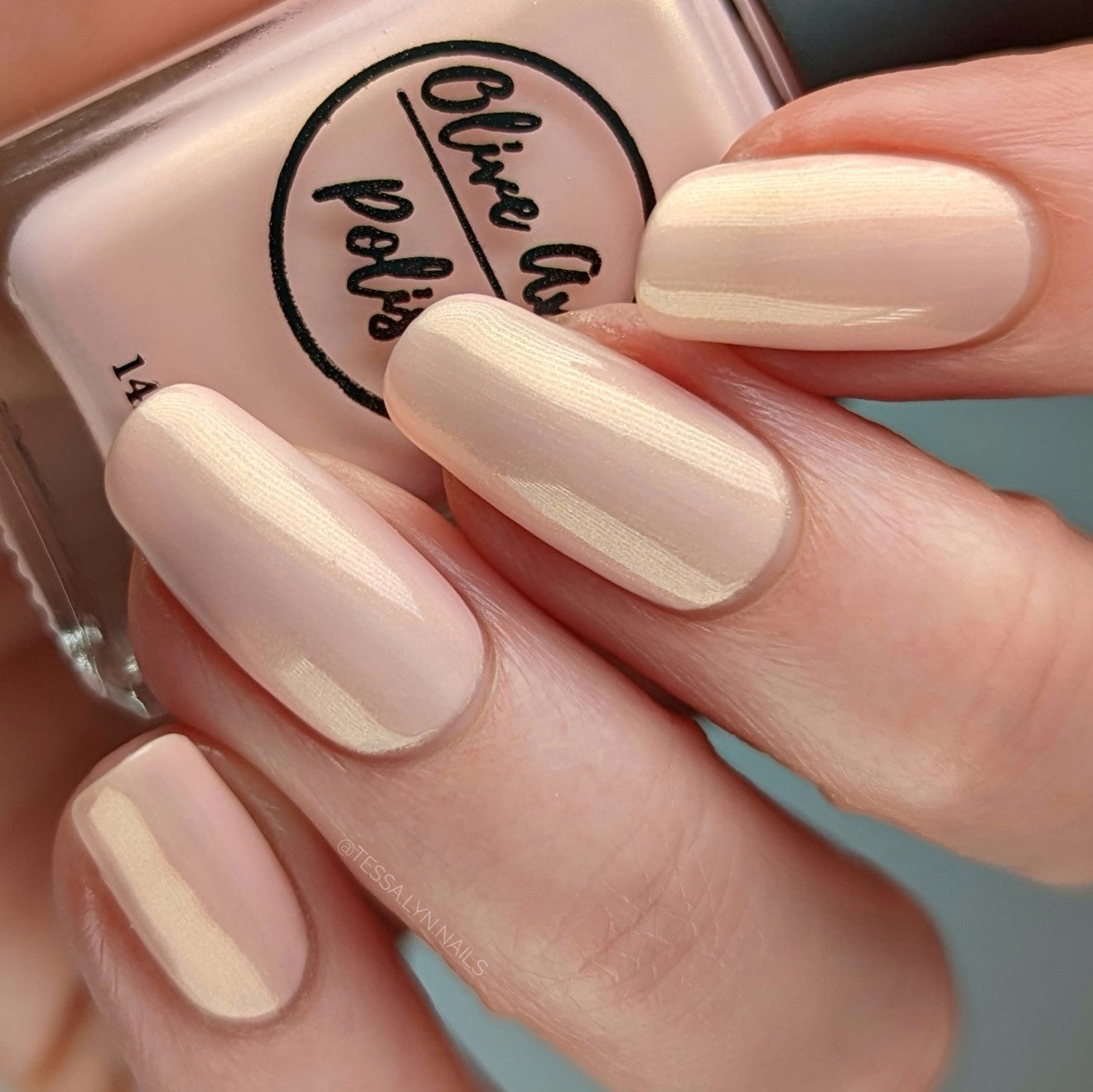 Pink nail polish with gold shimmer on pale skin tone
