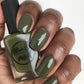 olive green nail polish swatch on medium deep skin tone