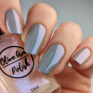 Sheer opal nail polish over blue nail polish swatch on pale skin tone