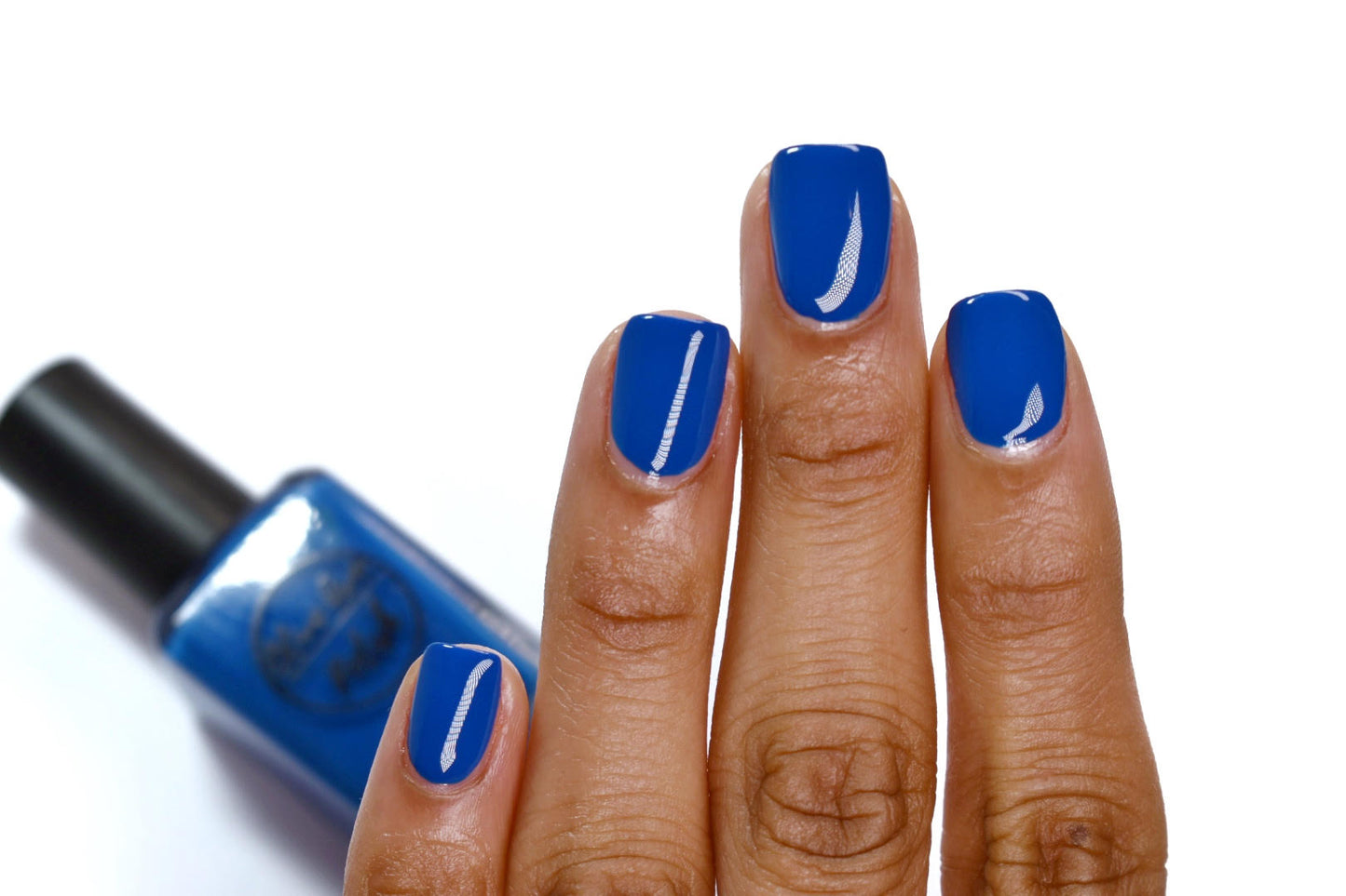 royal blue nail polish swatch on medium skin tone